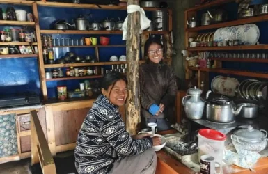 Annapurna Circuit Trek Guide Cultural Encounters Local residents smiling inside a traditional mountain kitchen featured in the Annapurna Circuit Trek Guide.