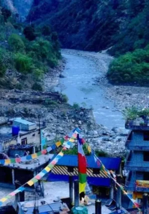Annapurna Circuit Trek Guide Classic Full Loop Vibrant prayer flags hanging over a mountain village river valley featured in the Annapurna Circuit Trek Guide.