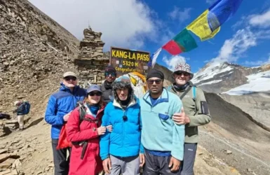 Annapurna Circuit Trek Guide Group Treks Group of happy hikers posing together at a high mountain pass sign featured in the Annapurna Circuit Trek Guide.